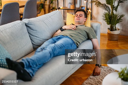 Young Man Sleeping On The Sofa At Home Young Man Sleeping On The Sofa At Home