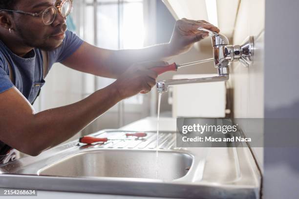 afroamerikanischer handwerker bei der arbeit - wasserrohr stock-fotos und bilder