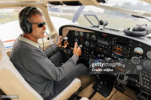 pilot sitting in a cockpit, flying a plane - private airplane stock pictures, royalty-free photos & images
