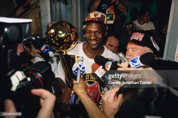 Michael Jordan, Shooting Guard and Small Forward for the Chicago Bulls addresses the media holding the Larry O'Brien NBA Championship Trophy in the...