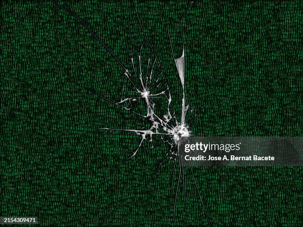 screen of a computer monitor with digital code and broken glass due to an impact. - fuera de servicio fotografías e imágenes de stock