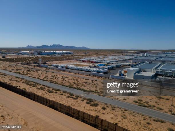 international border barrier wall between puerto anapra chihuahua mexico and sunland park new mexico at dawn with border patrol vehicle cruising by - international border stock pictures, royalty-free photos & images