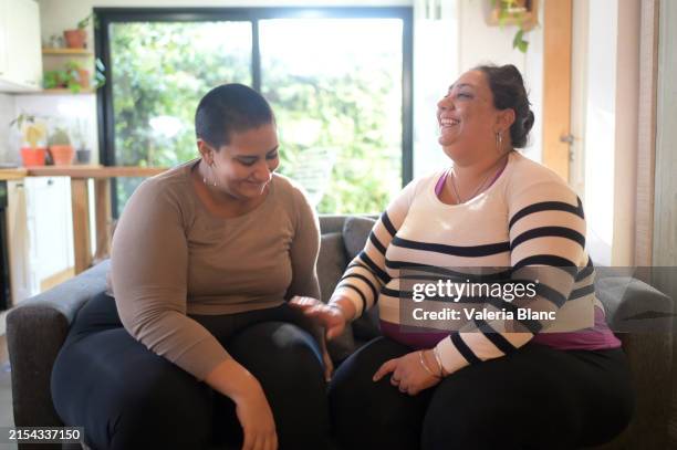 sisters having a nice time on the couch - obesity stock pictures, royalty-free photos & images