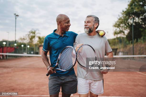 zwei freunde tennisspiel - tennisspieler stock-fotos und bilder