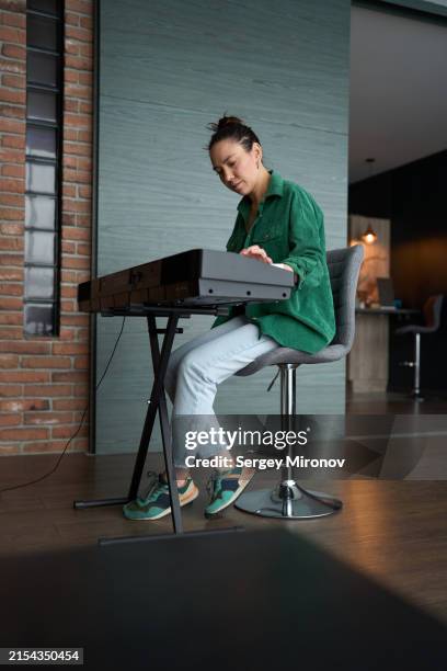 woman concentrated on playing electronic keyboard - keyboard player stock pictures, royalty-free photos & images