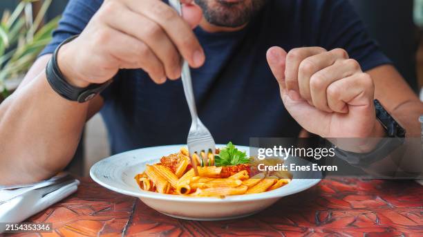 un hombre comiendo tagliatelle al ragú de pasta tradicional italiana, también conocida como pasta boloñesa - salsa boloñesa fotografías e imágenes de stock