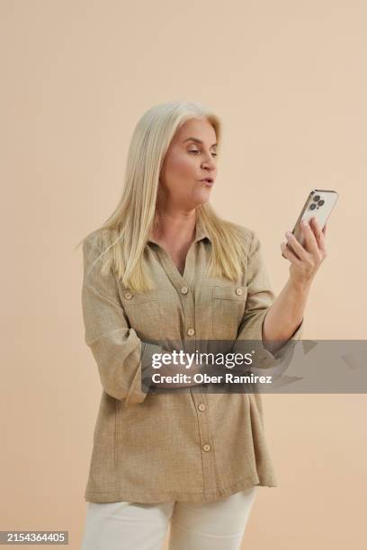 senior woman using a cell phone - medium shot stock pictures, royalty-free photos & images