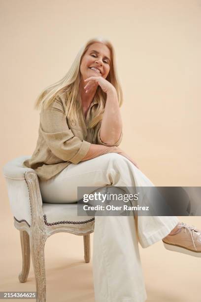 senior blonde woman portrait - fond beige photos et images de collection