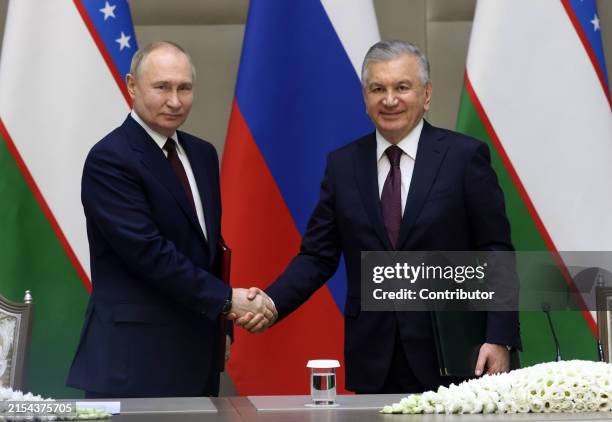 Russian President Vladimir Putin shakes hands with Uzbek President Shavkat Mirziyoyev during the signing ceremony at the Kuksaroy Presidential...