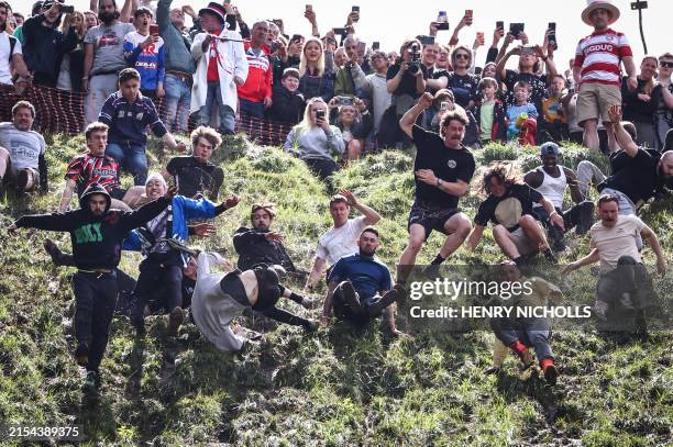 Competitors come tumbling down the hill in pursuit of a round Double Gloucester cheese during the annual Cooper's Hill cheese rolling competition...