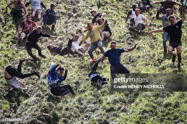 Competitors come tumbling down the hill in pursuit of a round Double Gloucester cheese during the annual Cooper's Hill cheese rolling competition...