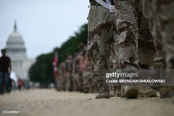 People wearing military fatigues arrive for the National Memorial Day parade held by the American Veterans Center in Washington, DC, on Memorial Day,...