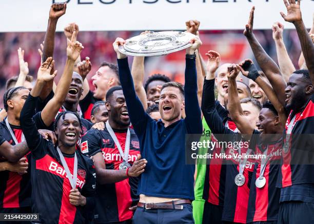 Head coach Xabi Alonso of Leverkusen celebrates the winning of championship trophy with Jeremie Frimpong of Leverkusen , Edmond Tapsoba of Leverkusen...