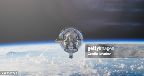 la estación espacial completa su órbita con el telón de fondo de la tierra - estación espacial fotografías e imágenes de stock