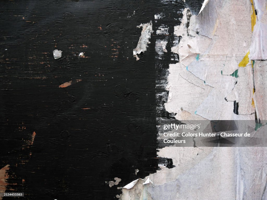 White papers glued and torn on a black painted wooden panel. Rough texture.
Close-up of the boundary of a construction site in Montreal, Quebec, Canada.
Natural light, colors and patina.