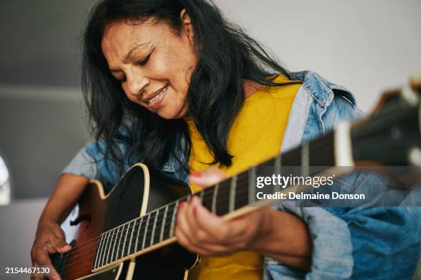 mature woman learning guitar - music therapy stock pictures, royalty-free photos & images
