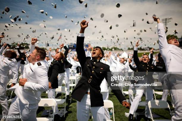Naval Academy graduates throw their hats into the air at the conclusion of their graduation ceremony at the Navy-Marine Corps Memorial Stadium at the...