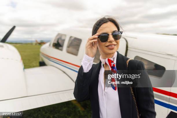 stewardess in front of an airplane - flight attendant stewardess uniform stock pictures, royalty-free photos & images