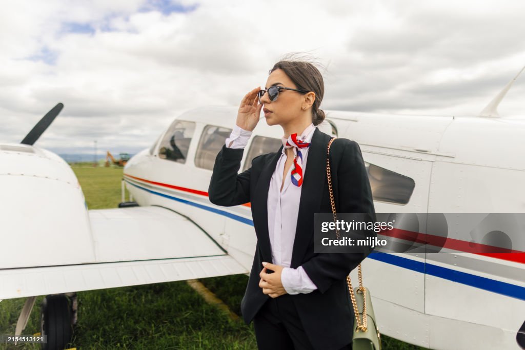 Stewardess in front of an airplane