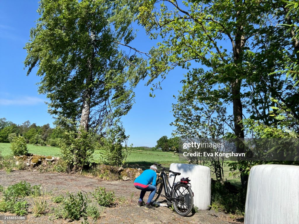 Woman repairing her broken down bike