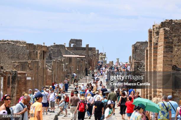 Crowd of tourists on the main street of the Pompeii archaeological excavations.