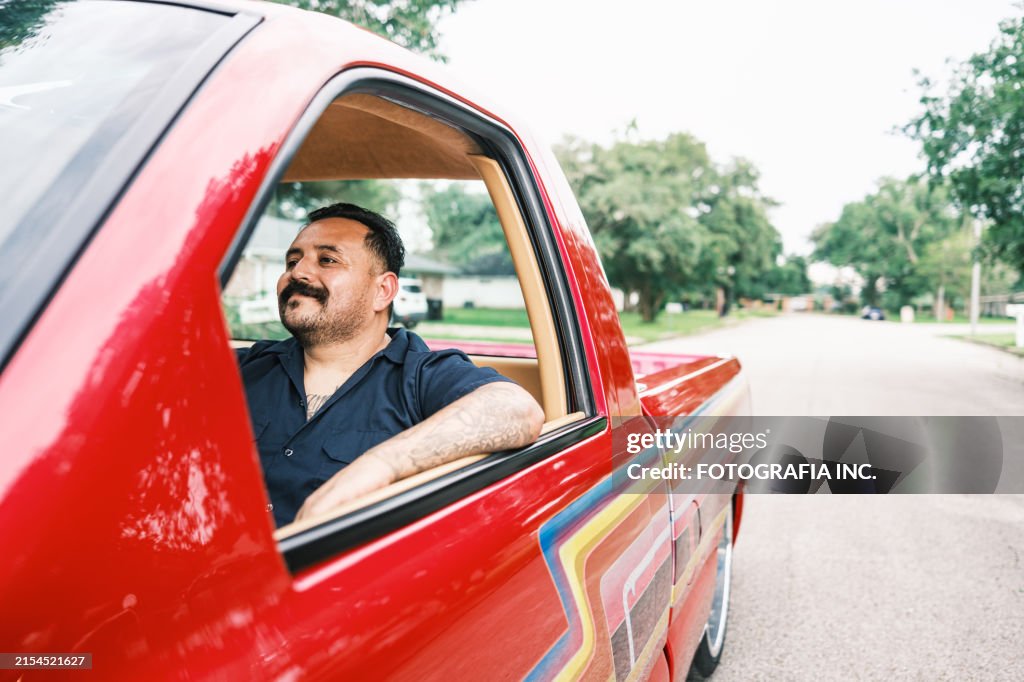 Mexican American man proudly displays his Low Rider Truck