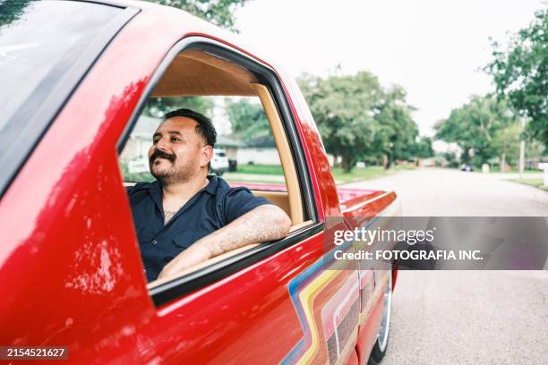 mexican american man proudly displays his low rider truck - mexican american stock pictures, royalty-free photos & images