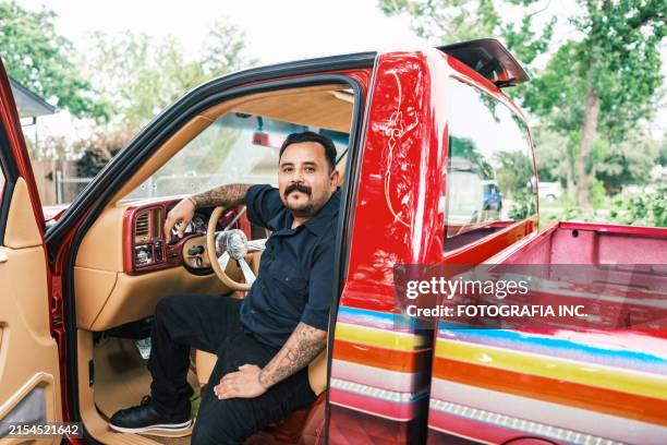 mexican american man proudly displays his low rider truck - mexican american stock pictures, royalty-free photos & images