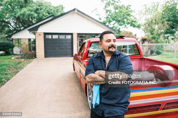 mexican american man proudly displays his low rider truck - mexican american stock pictures, royalty-free photos & images