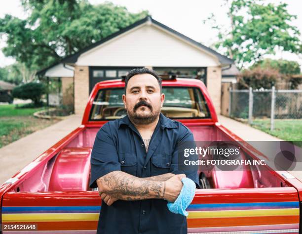 mexican american man proudly displays his low rider truck - mexican american stock pictures, royalty-free photos & images