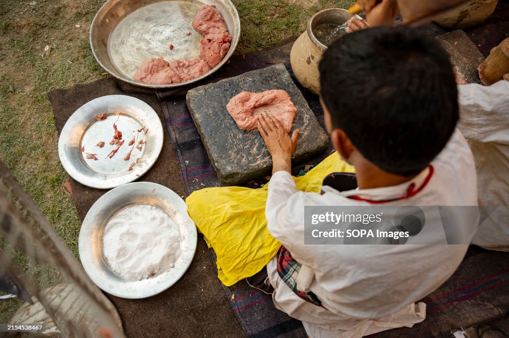 A traditional Kashmiri chef smashes lamb meat to prepare a...