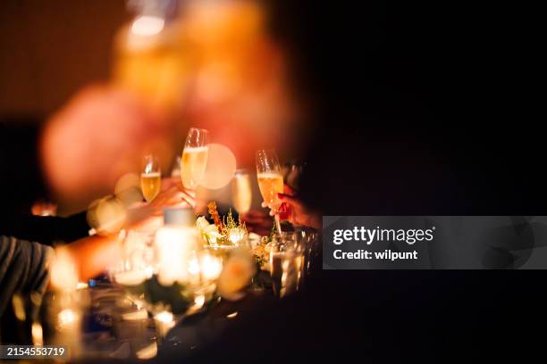 brindis de celebración oscurecido - brindar fotografías e imágenes de stock