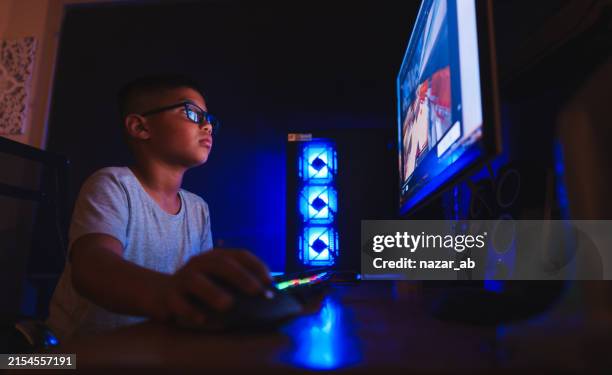 boy playing an online computer game. - child computer game stock pictures, royalty-free photos & images