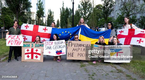Activists hold banners and flags of Georgia, the EU and Ukraine near the Embassy of Georgia during an action of solidarity with the Georgian people...