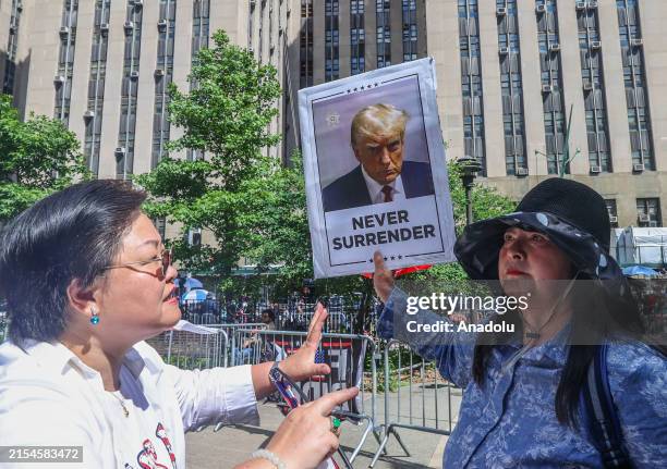 Trump supporter carries a placard that reads 'never surrender' outside the Manhattan courthouse where former US President Donald Trump's hush money...