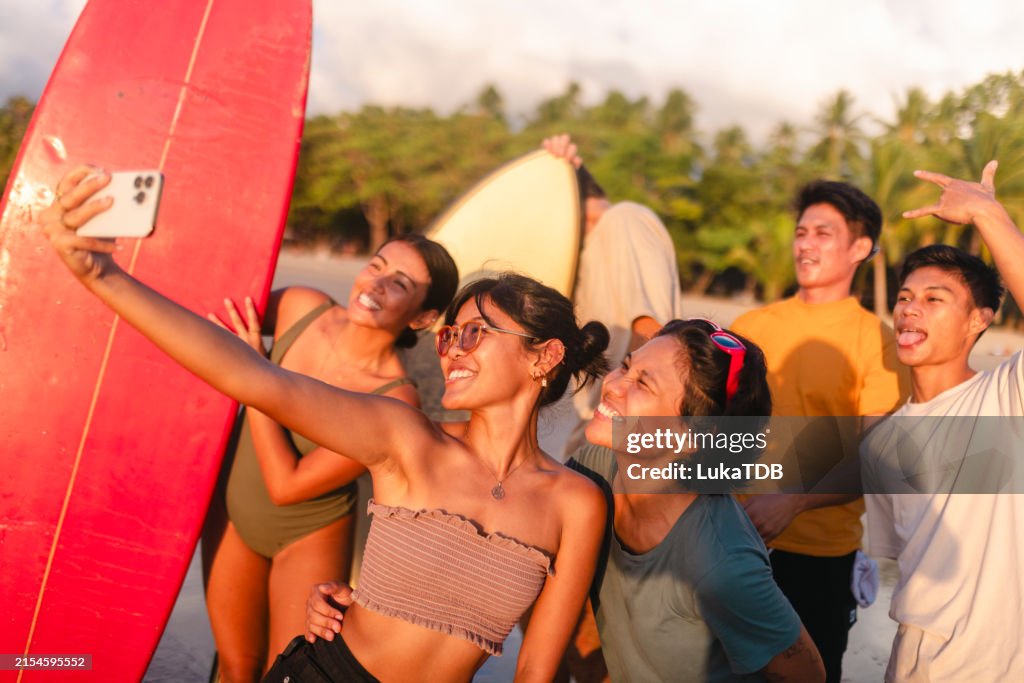 A diverse group of friends take a selfie photo before surfing