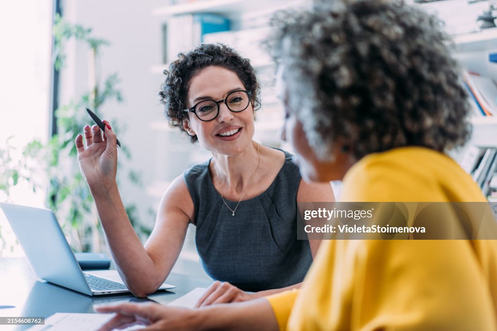 Colleagues discussing project at workplace.