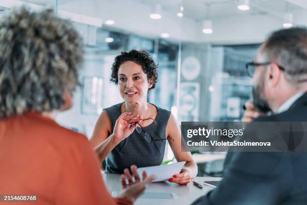 groupe d’hommes d’affaires parlant au bureau. - femme dans un groupe dhommes photos et images de collection
