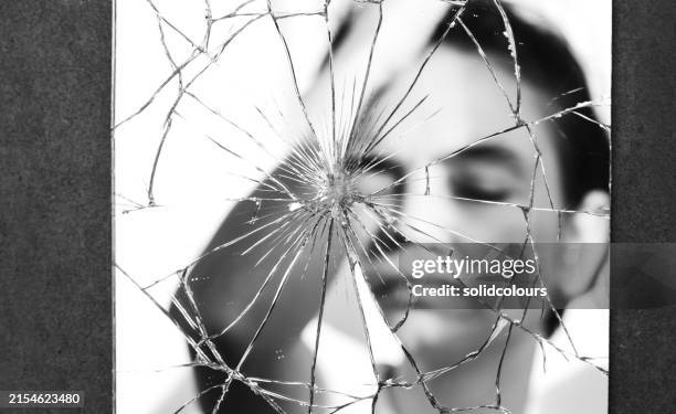 depressive frau im zerbrochenen spiegel - gebrochen stock-fotos und bilder
