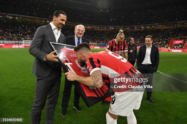 Olivier Giroud of AC Milan kisses an enmarked shirt after his farewell to AC Milan speech during the Serie A TIM match between AC Milan and US...