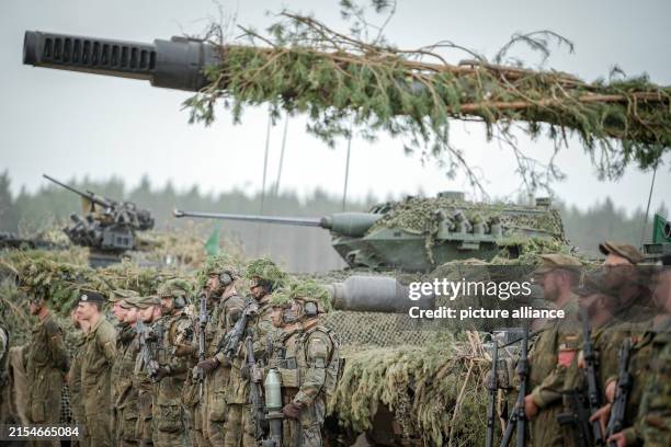 May 2024, Lithuania, Pabrade: Bundeswehr soldiers stand in front of the 2000 self-propelled howitzer and the Puma infantry fighting vehicle at the...