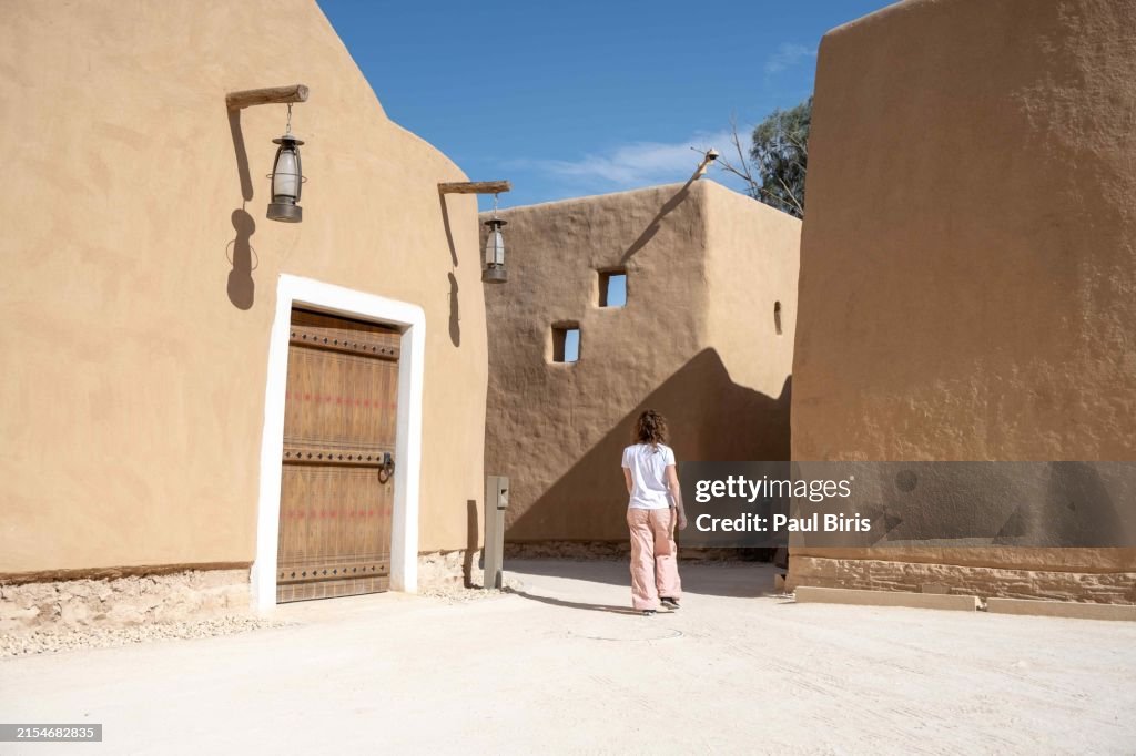 Mid adult woman tourist walking and admiring the Ruins of Salwa Palace, Ad Diriyah, At-Turaif District , Riyadh, Saudi Arabia