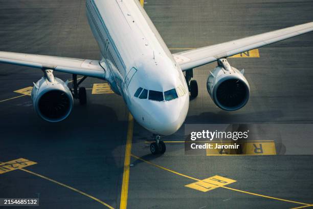 airplane taxiing at airport - straßenmarkierung stock-fotos und bilder