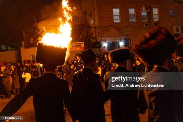 Orthodox Jews come out into the streets of the Borough Park neighborhood to dance, sing, and light fires in the streets during the celebration of the...