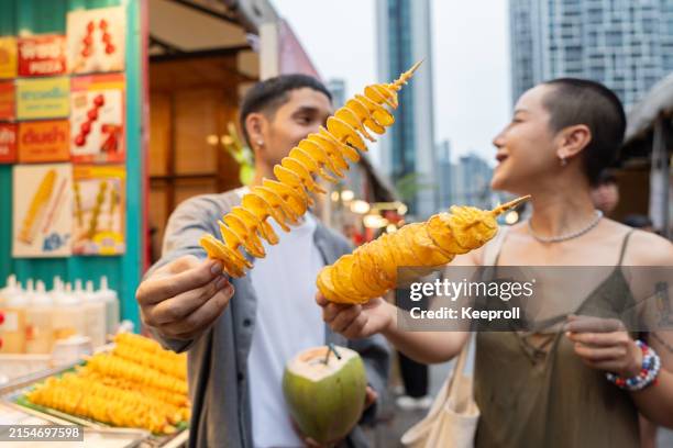 asian couple enjoying with fried potato - food festival stock pictures, royalty-free photos & images