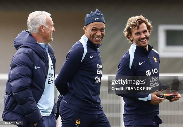 France's head coach Didier Deschamps looks at France's forward Kylian Mbappe , flanked by France's forward Antoine Griezmann during a training...