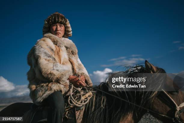 proud young teen kazakh eagle hunters riding horses looking at camera bayan olgii, west mongolia - mongolian culture stock pictures, royalty-free photos & images