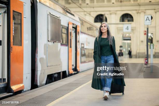 mature woman going on a journey - railroad station platform stock pictures, royalty-free photos & images
