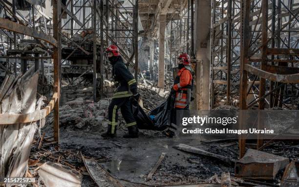Rescuers carry a dead body during a rescue operation at ‘Epicentr K’ hypermarket after Russian air attack on May 26, 2024 in Kharkiv, Ukraine. In the...
