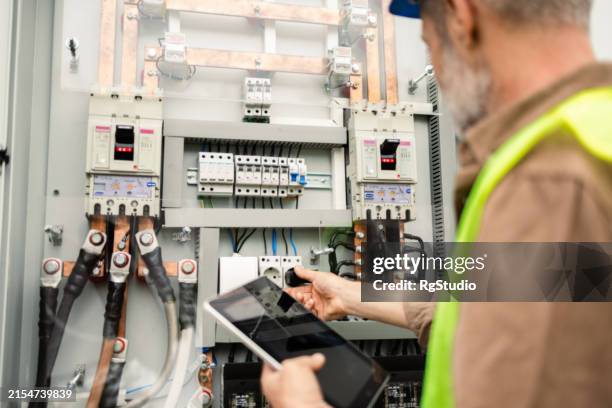 mature engineer repairing a solar energy generator - gerador imagens e fotografias de stock